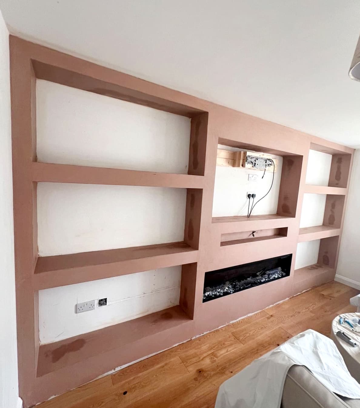 Bespoke plastered media wall and shelving, finished by TJ Plastering