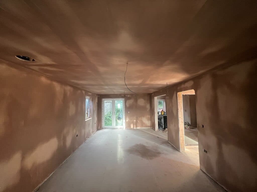 A freshly plastered open plan room, walls and ceiling finished, ready to decorate